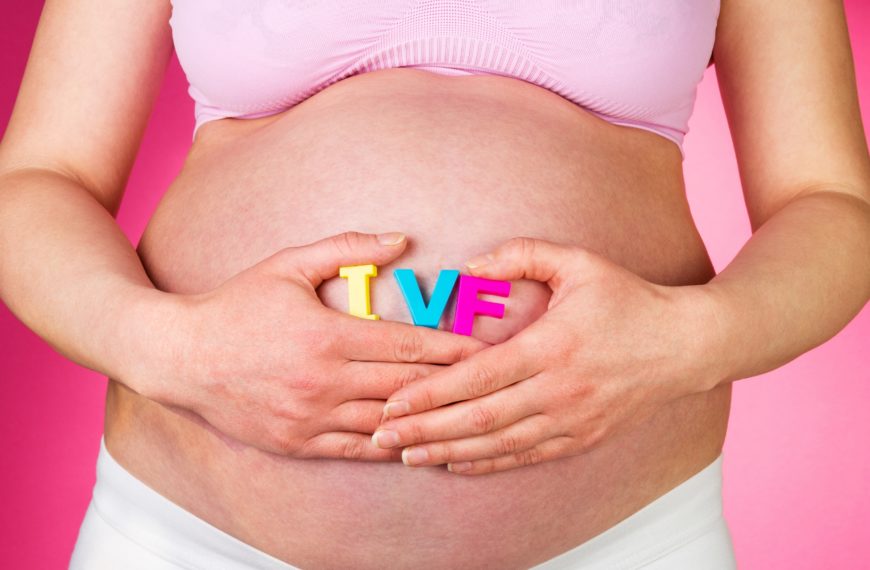 Vientre de mujer embarazada con letras “IVF”, representando un embarazo por fecundación in vitro con óvulos donados